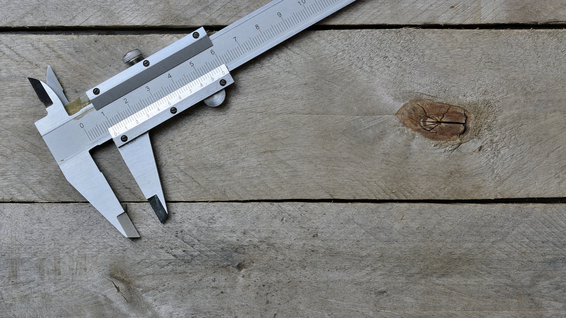 Calipers on wooden background